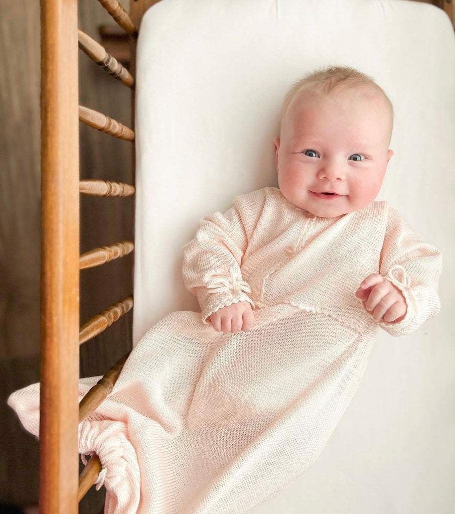Smiling newborn in ivory mercerized pima baby gown
