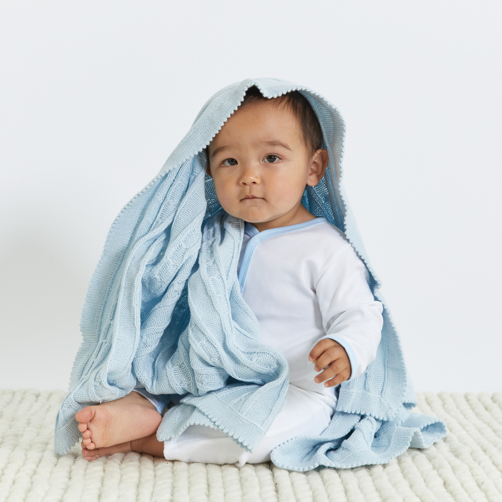 baby boy wearing white with blue Pima Romper