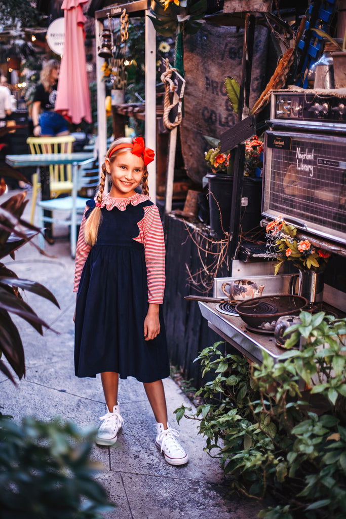 Young girl wearing Red Striped Ruffled Jersey Blouse with navy dress
